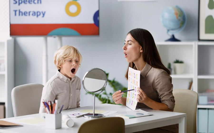 معلمی که هنگام آموزش تلفظ یک حرف، شکل دهان خود را به کودک نشان می‌دهد و کودک با تمرکز همان حرکت را تکرار می‌کند.